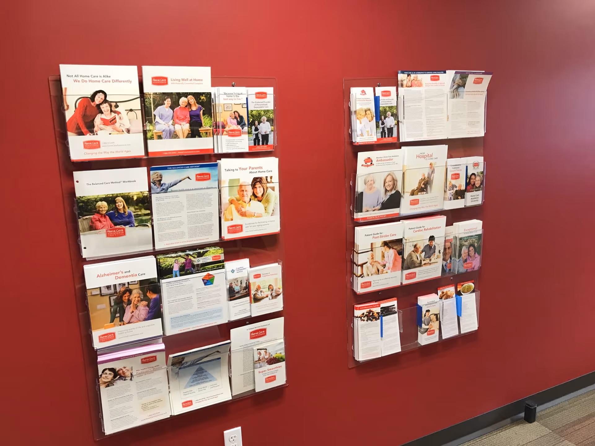 Two brochure racks mounted on a red interior wall with pamphlets.