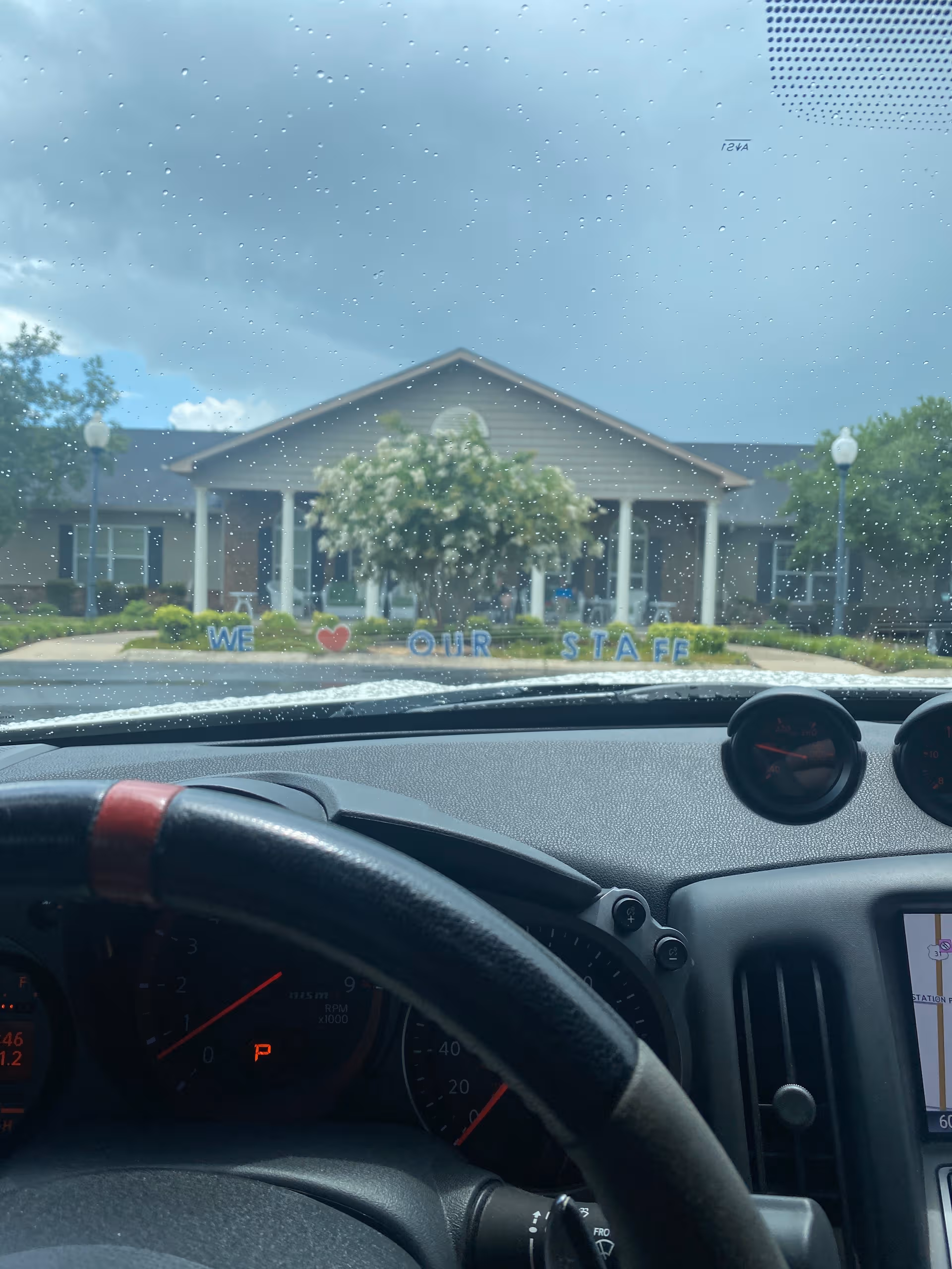 Exterior view of Willow Springs Senior Living seen from a car, with a staff appreciation sign.