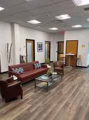 Interior lounge area in a senior living facility with leather seating and coffee table.