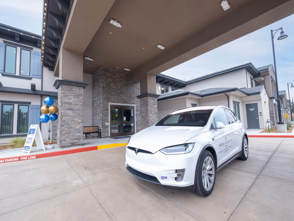Exterior view of WellQuest of Granite Bay entrance with a white Tesla parked nearby.