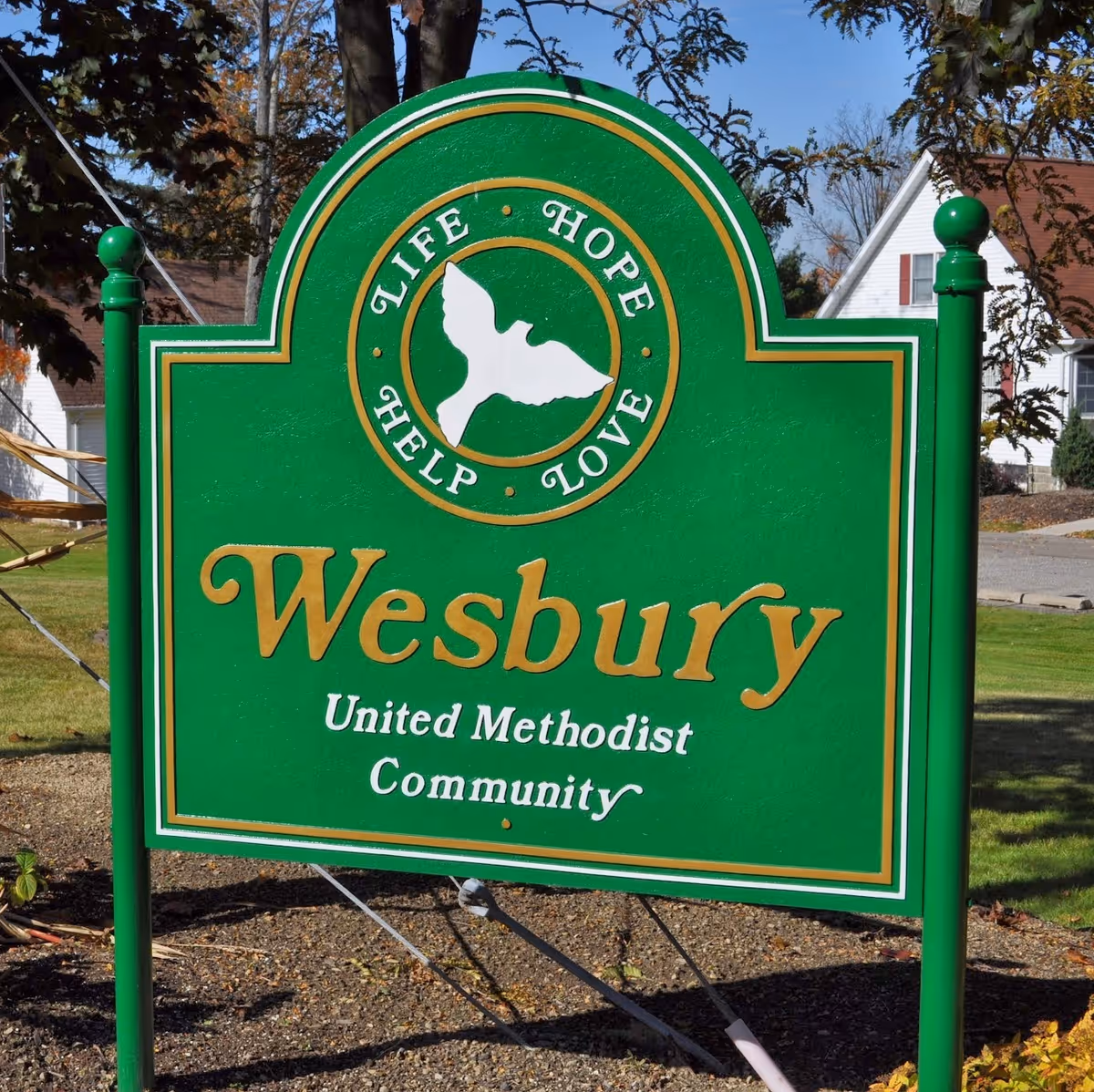 Green Wesbury sign reading United Methodist Community stands in front yard.
