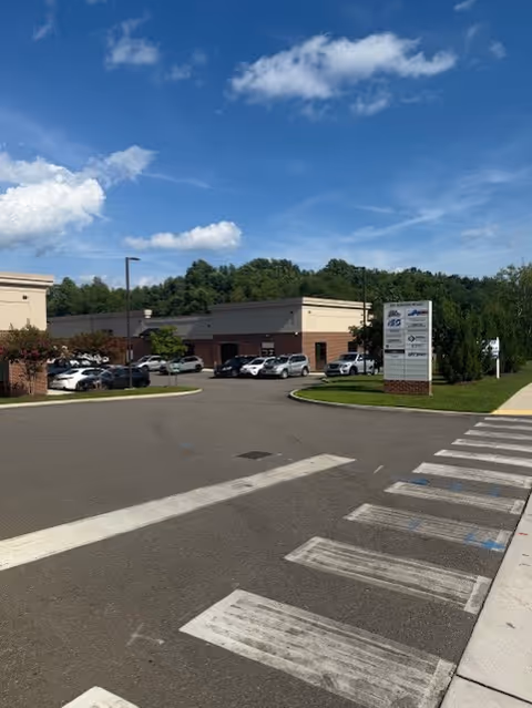 Exterior view of Respire Homecare Services building with parking lot and blue sky.