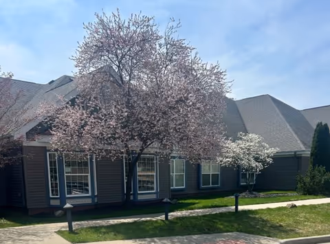 Exterior view of Caretel Inns of St. Joseph with blooming trees in front.