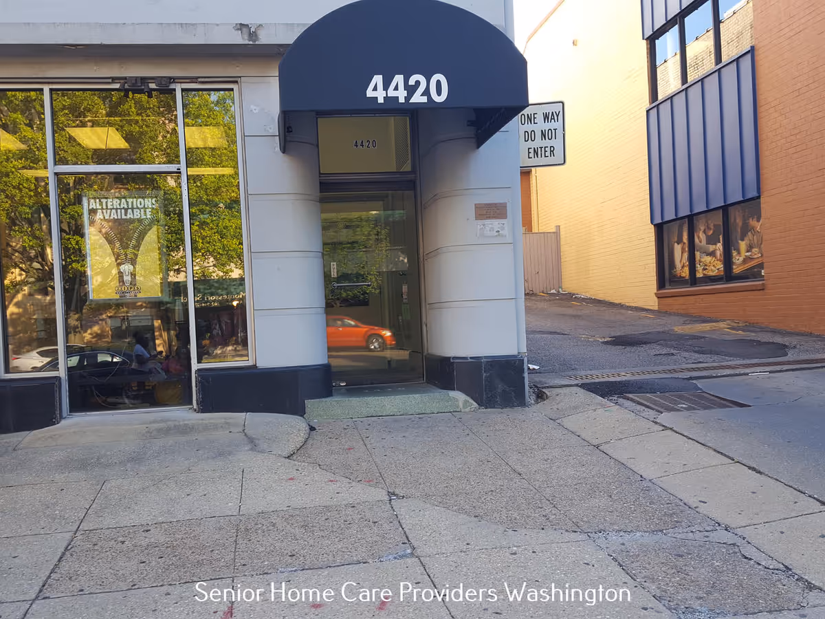 Entrance to a building with a curved blue awning and address 4420.