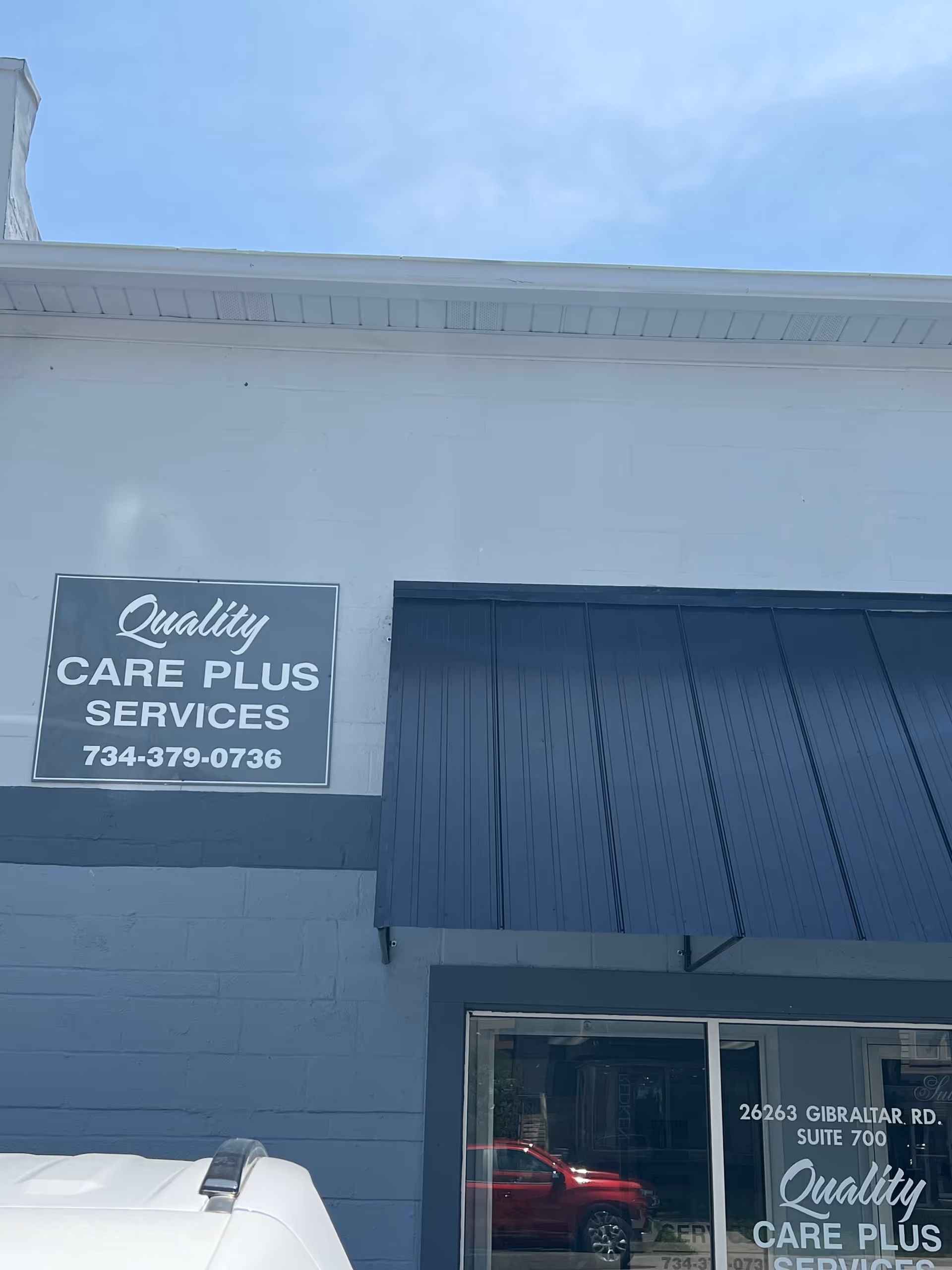 Exterior of a building with a blue awning and Quality Care Plus Services sign.