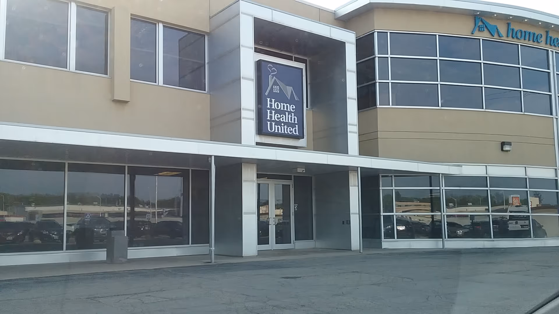 Exterior view of a modern building with glass storefront and Home Health United sign.