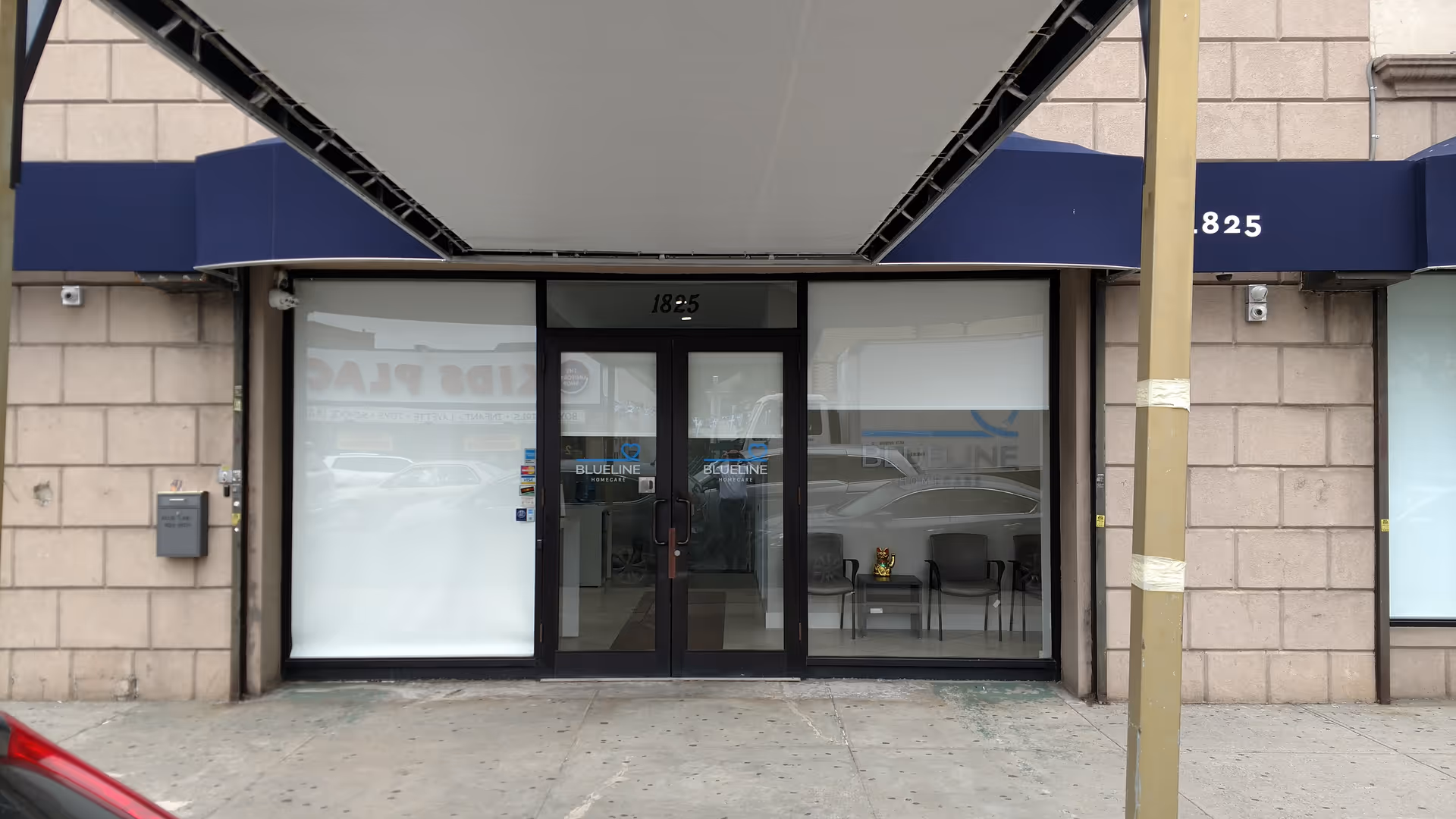 Storefront entrance for Blue Line Home Care with glass doors and a blue awning.