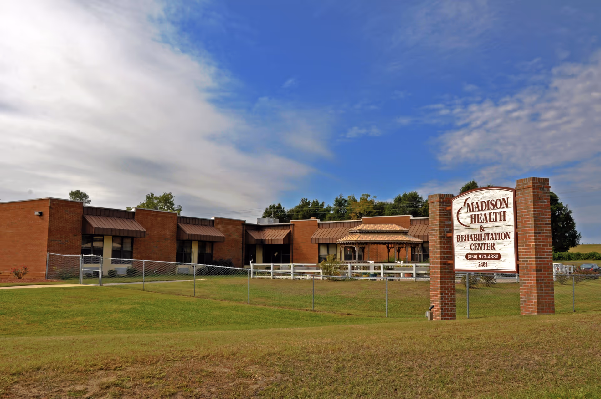 Exterior view of Madison Health and Rehabilitation Center with a brick building and sign.