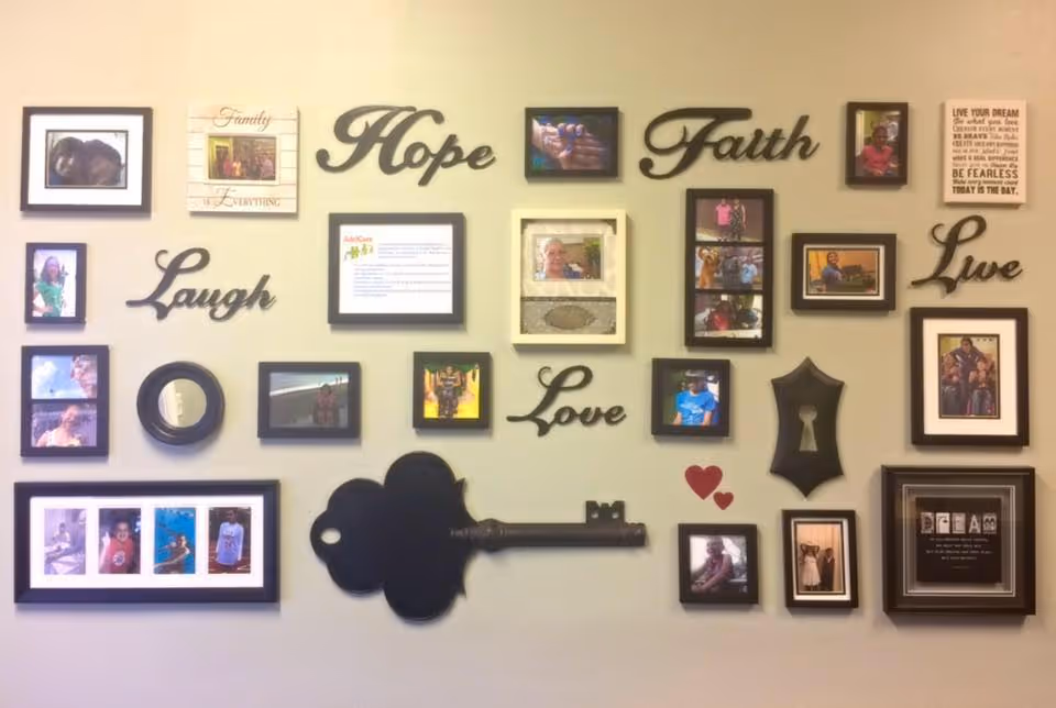 Interior wall collage of framed photos and inspirational words with a large key silhouette.