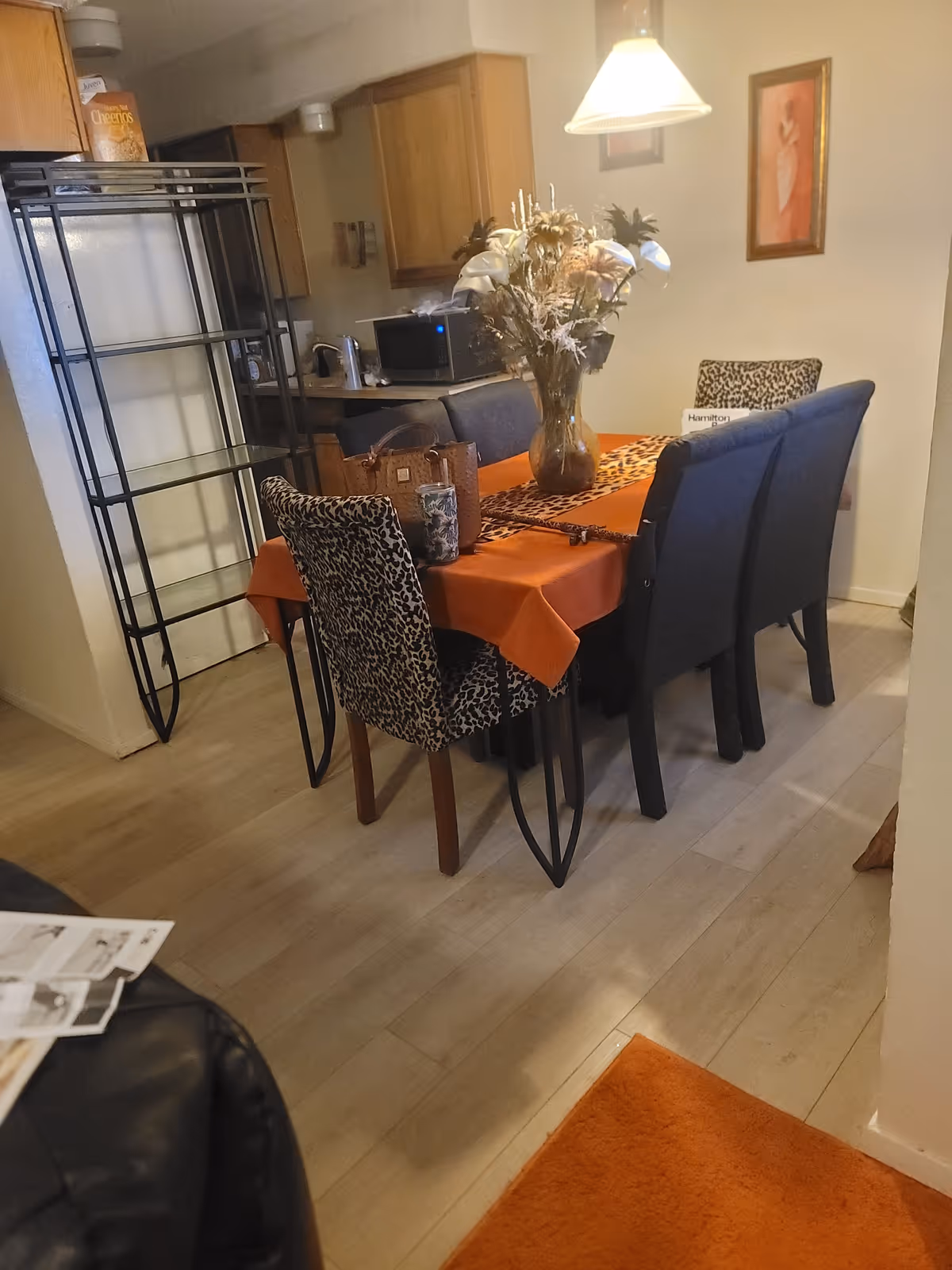 Dining area in a senior living unit with orange tablecloth and leopard-pattern chairs