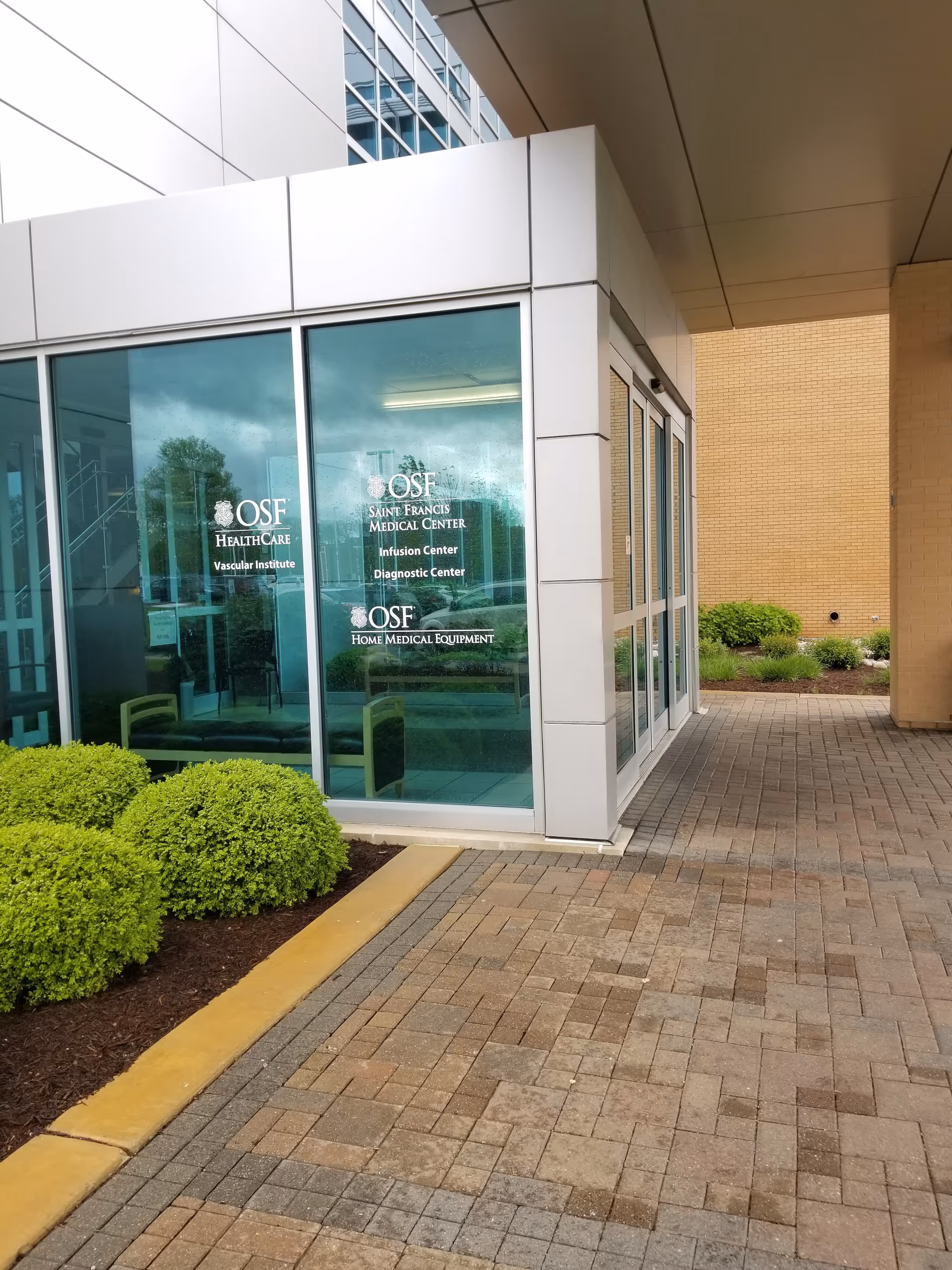 Exterior entry of OSF Home Medical Equipment Administration Office with glass doors and landscaping