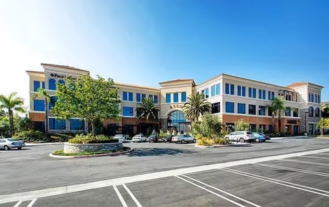 Exterior view of FirstLight Home Care of Simi Valley, a multi-story facility with palm trees.