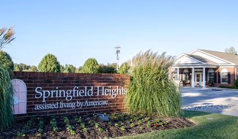 Exterior view of Springfield Heights assisted living entrance with brick sign and manicured landscaping.