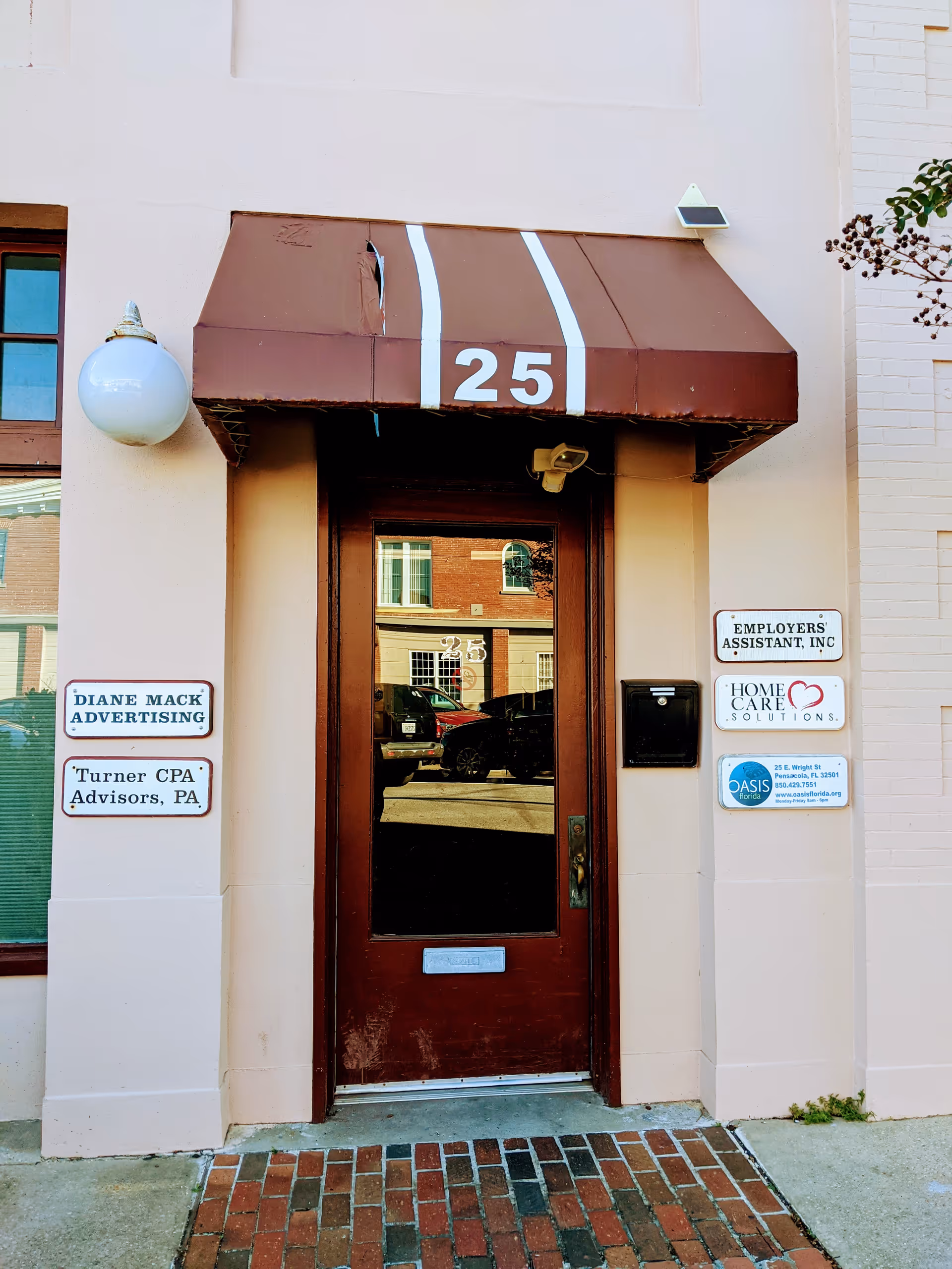 This is an exterior entrance with a brown awning marked 25 and Home Care Solutions signs.