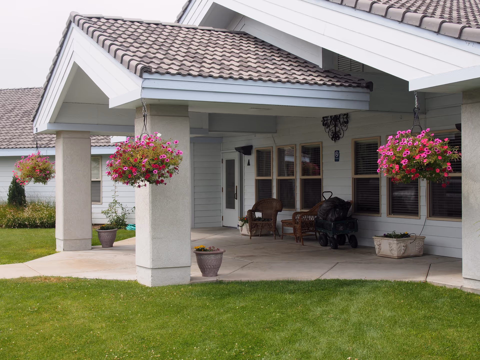 Front entrance of Chandler House with a covered porch and hanging flower baskets.