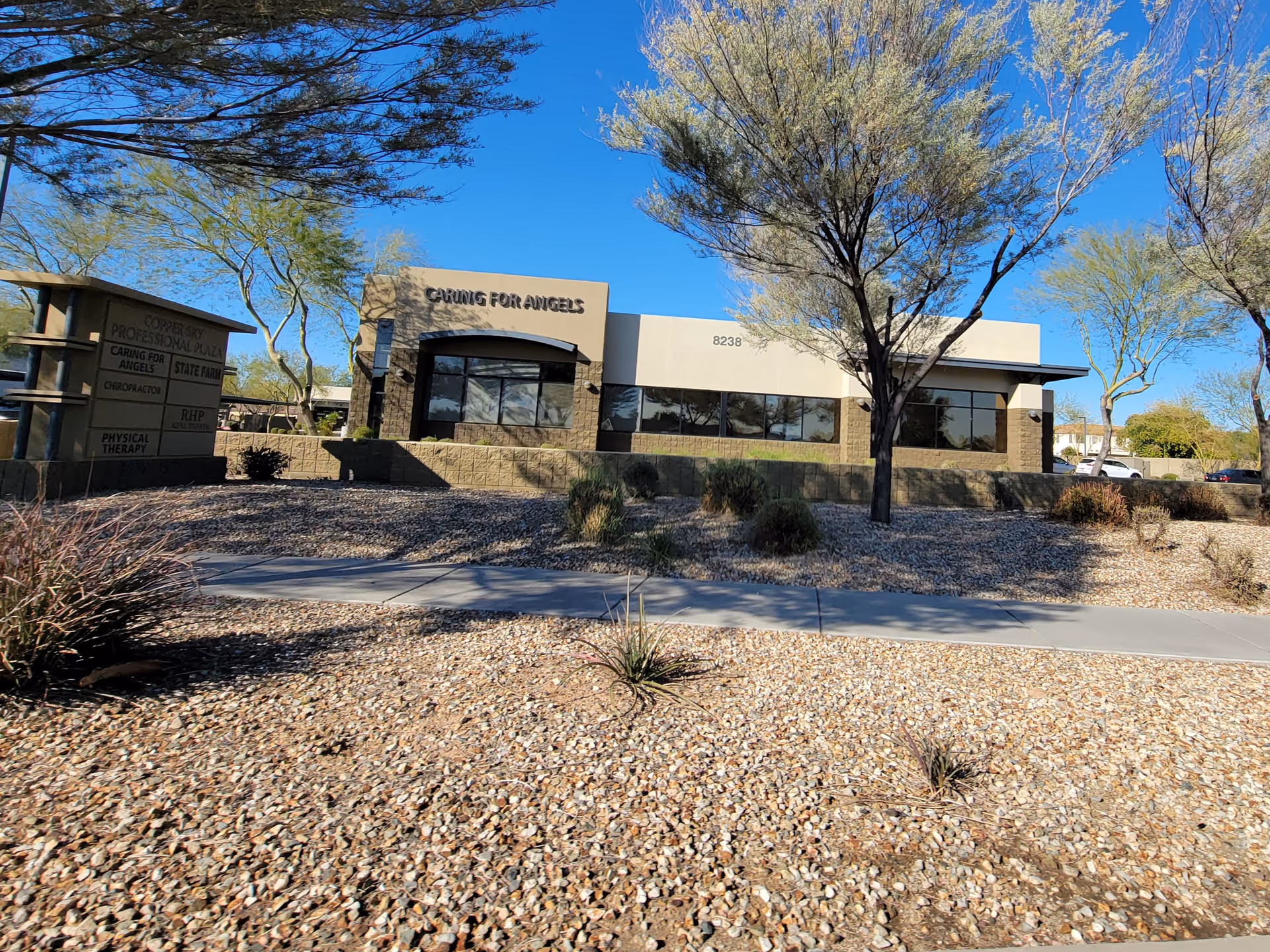 Exterior view of Caring For Angels LLC building with desert landscaping and blue sky.