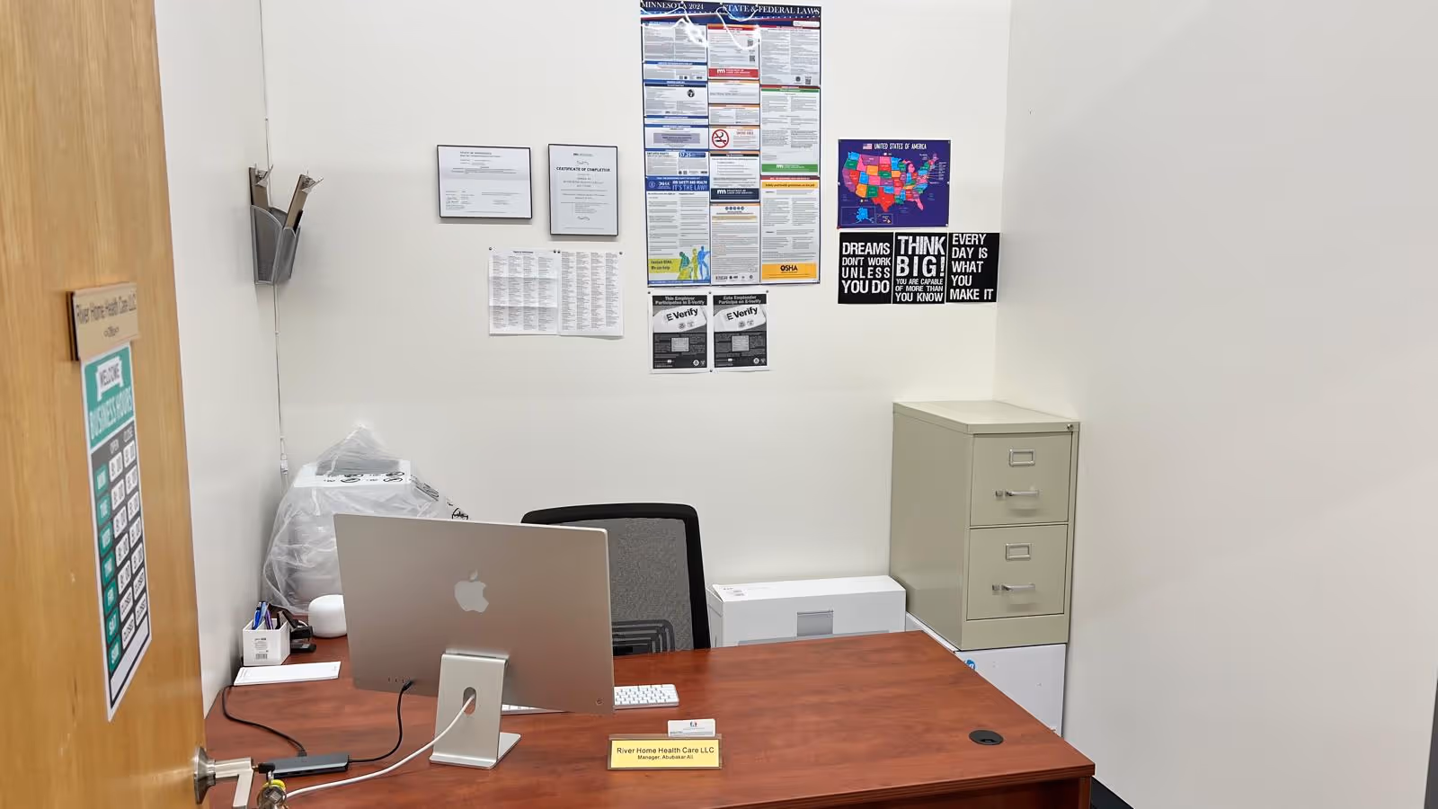 River Home Health Care LLC reception desk with computer and wall posters.