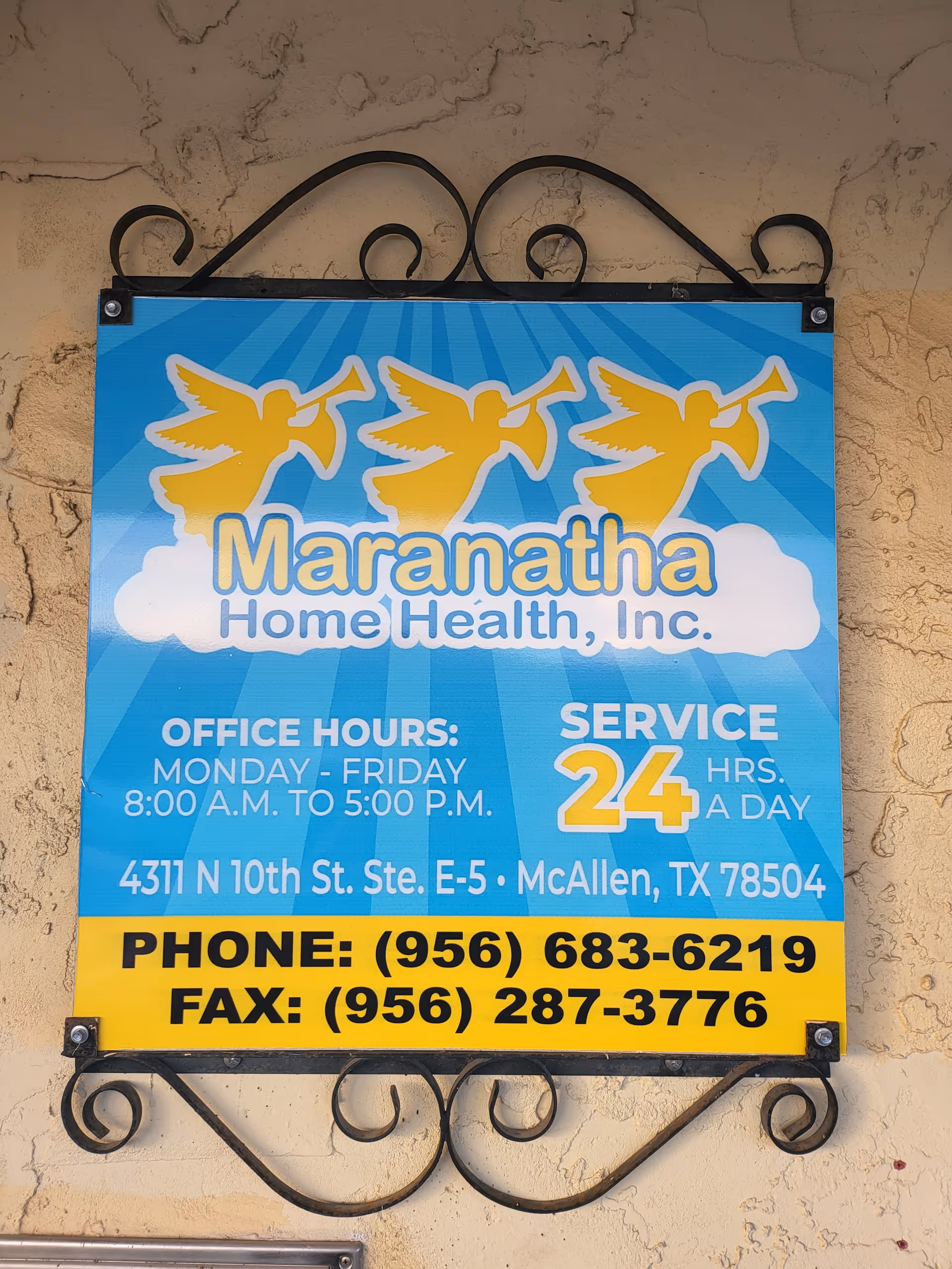 Blue sign reading Maranatha Home Health, Inc., with yellow angel graphics, mounted on a beige wall.