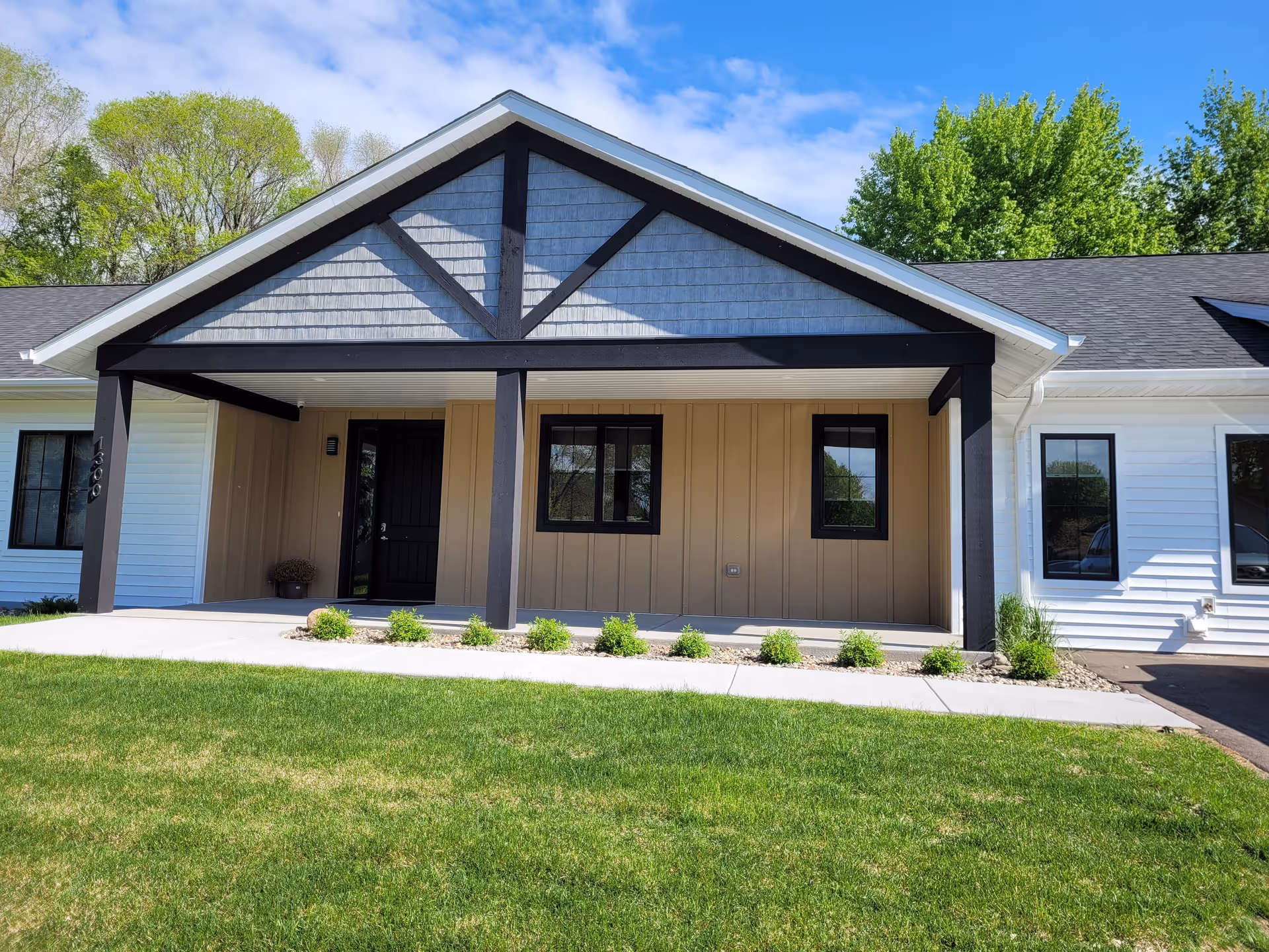Modern single-story building with a covered front porch and landscaped lawn.