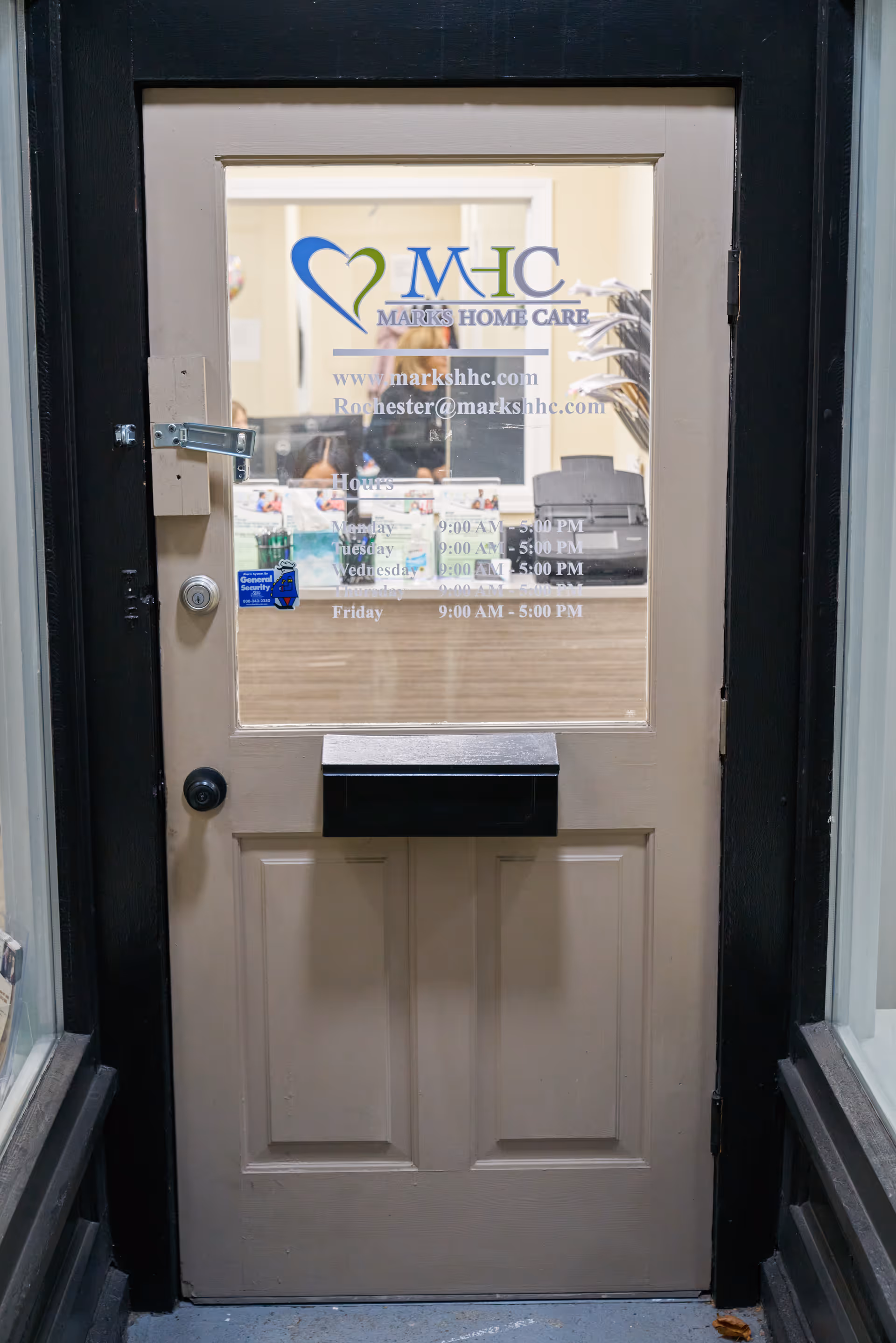 Front entrance door with Marks Home Care logo and hours visible through glass.