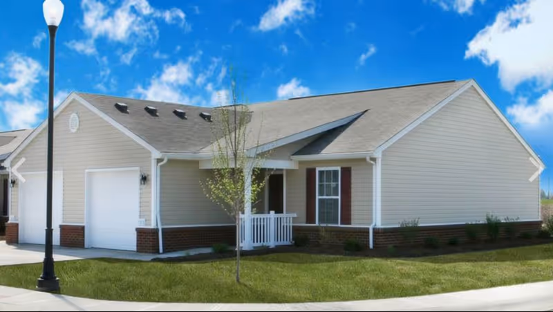 Front view of Wauseon Senior Villas: beige single-story residence with front porch.