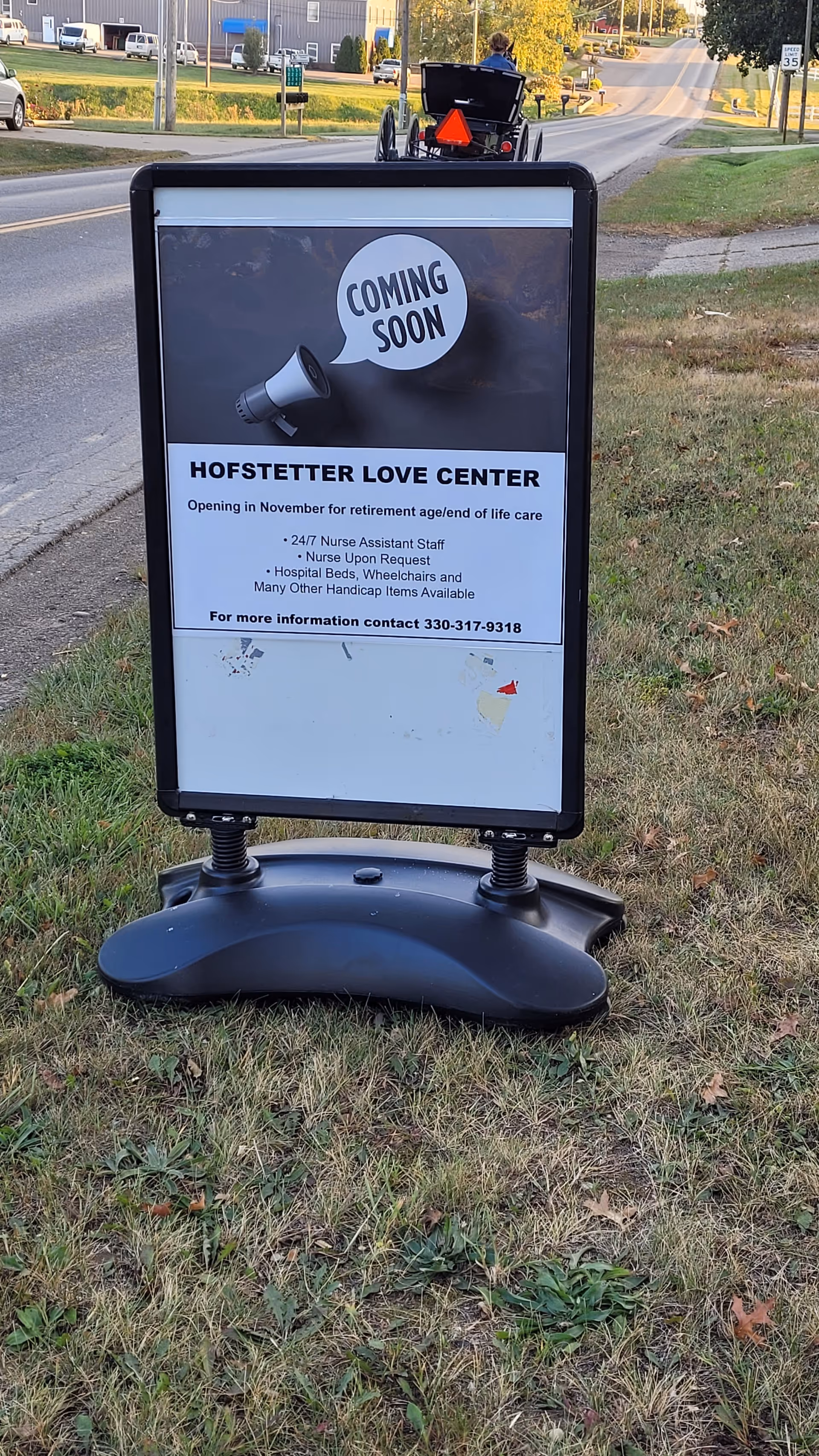 Outdoor signboard advertising Hofstetter Love Center on a grassy roadside lawn