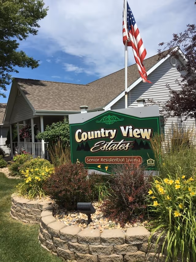 Country View Estates sign near a landscaped rock bed in front of a residential building.