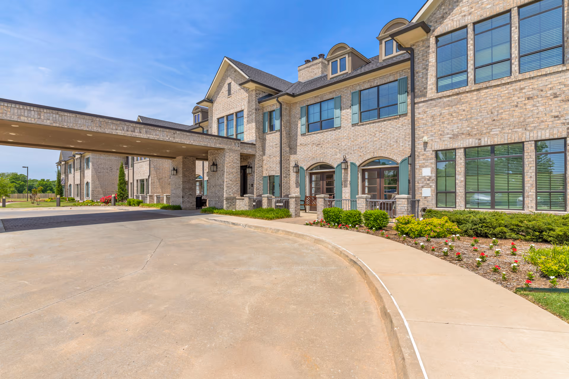 Bellarose Senior Living facility exterior with brick facade, porte-cochère entrance, and landscaped walkway.