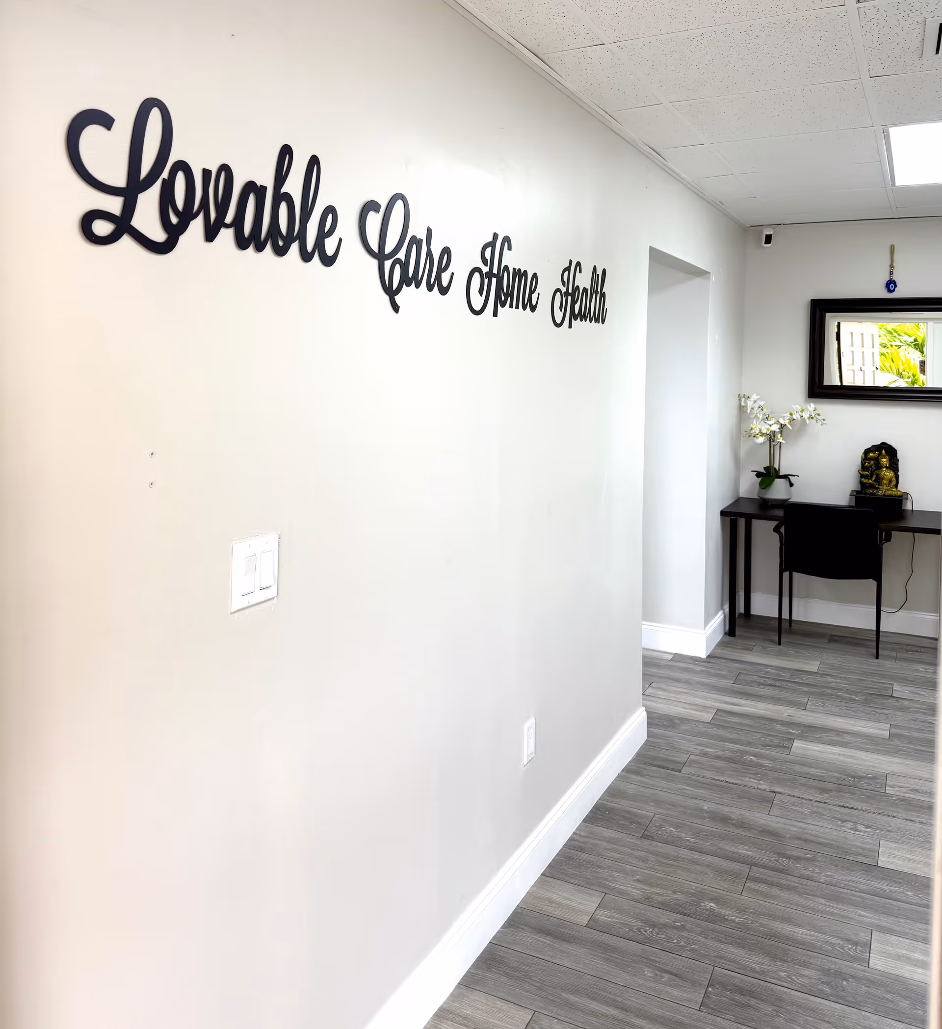 Interior hallway with 'Lovable Care Home Health' sign and a desk.