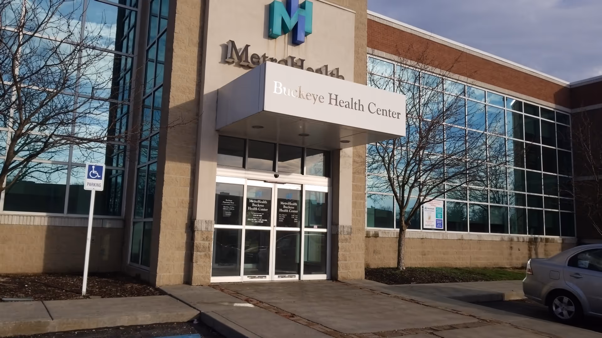 Exterior view of MetroHealth Buckeye Health Center entrance with glass facade and sign.