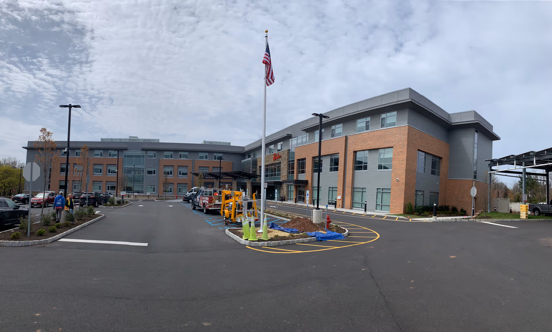 Exterior view of Parker at Somerset facility with a brick facade, glass entrance, and parking lot.