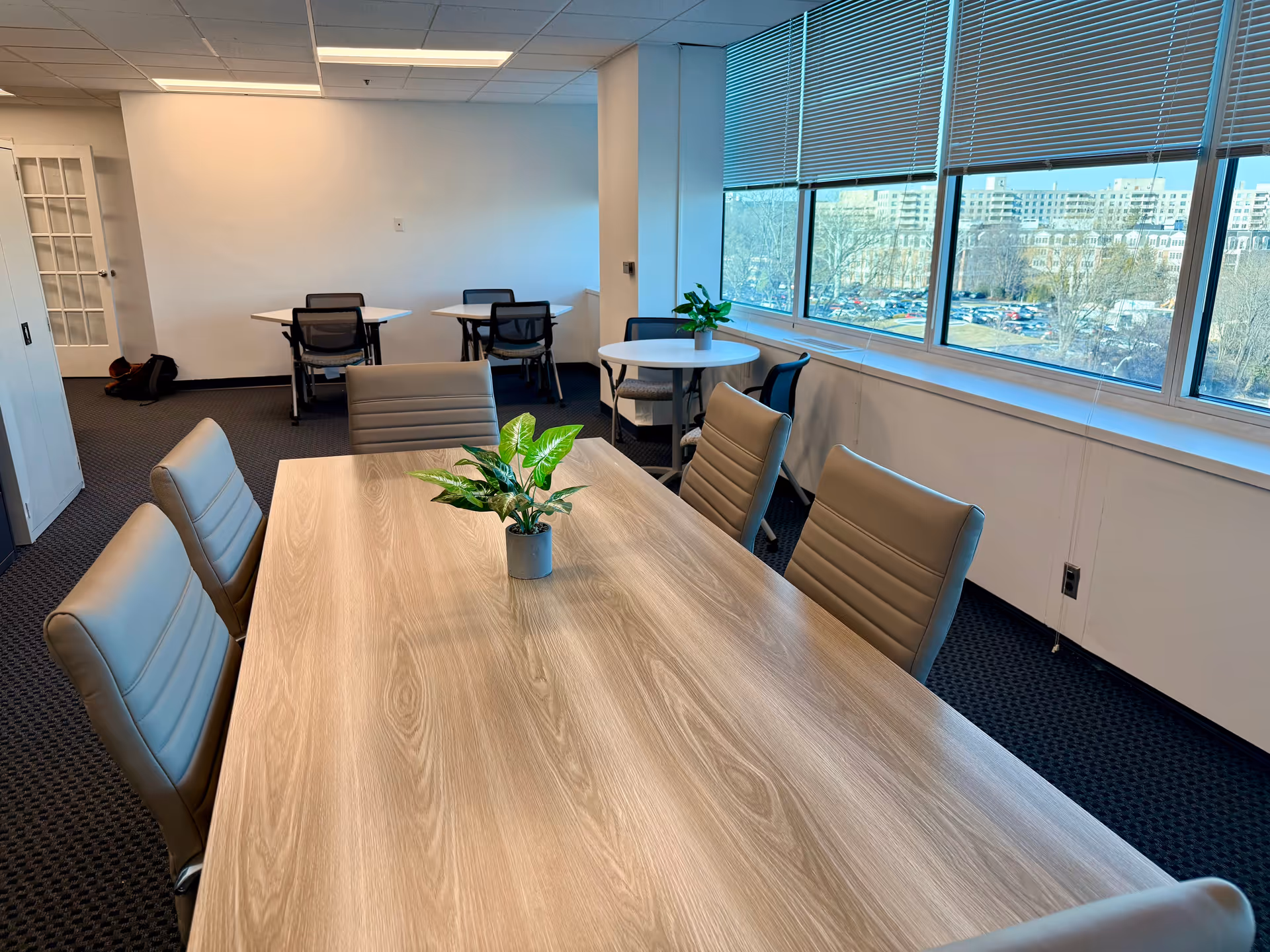Modern conference and dining room in a facility, featuring a long table and windows.