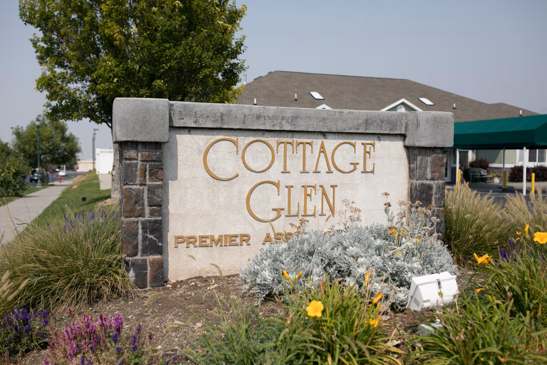 Front entrance sign reads Cottage Glen with landscaping and a building in background