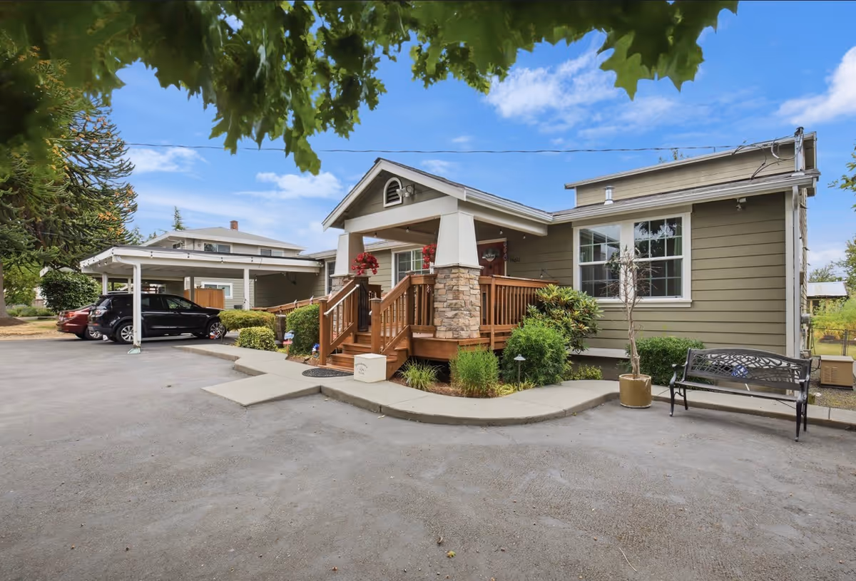 Exterior view of a single-story senior care facility with a front porch and landscaping.