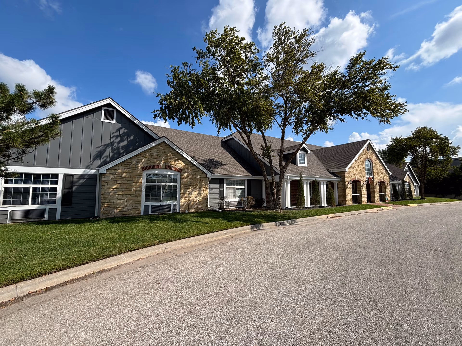 Exterior view of a single-story senior living facility with multiple front entrances along the street.