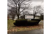 Exterior view of Cortland Park Rehabilitation and Nursing Center sign in landscaped front yard