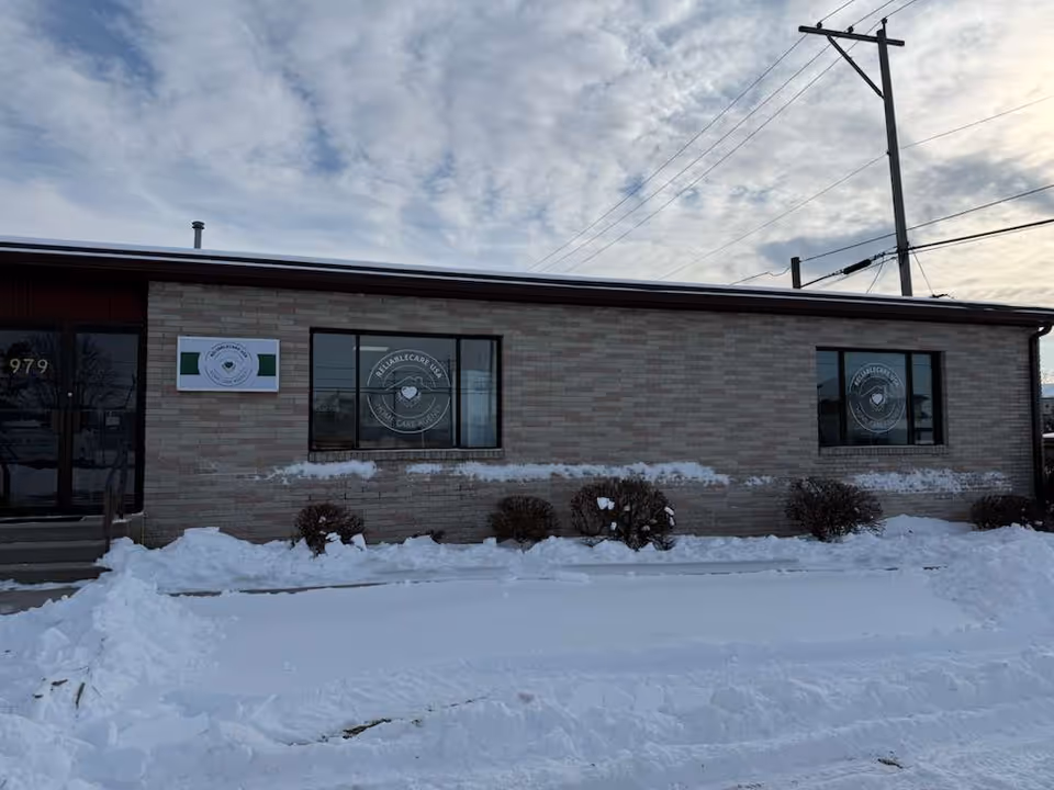 Exterior view of Reliablecare USA facility with brick walls, snow, and windows.