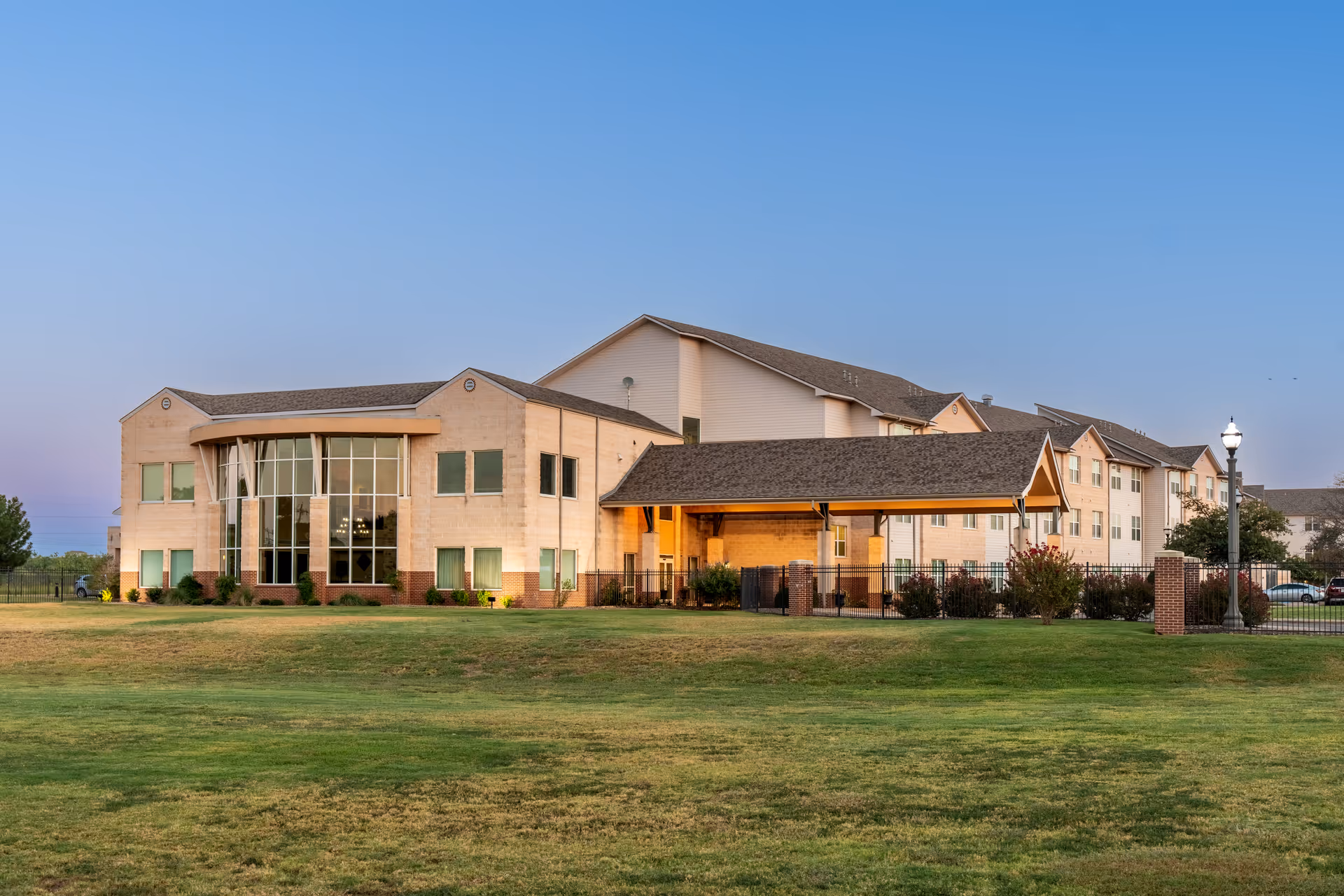 View of Wesley Court senior living facility exterior with manicured lawn and entrance canopies.