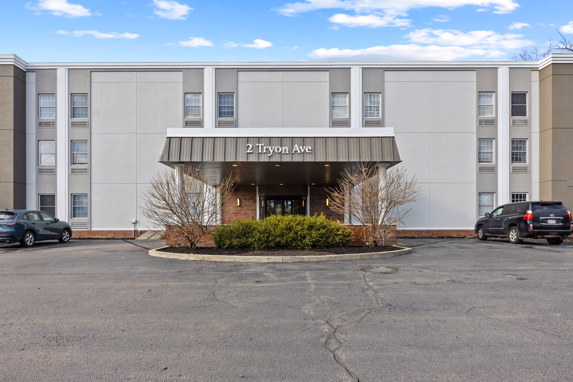 Exterior view of Provincial Glenville senior living facility front entrance with a canopy.