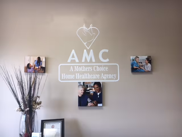 Interior wall displaying AMC logo with photos, a vase, and a certificate.