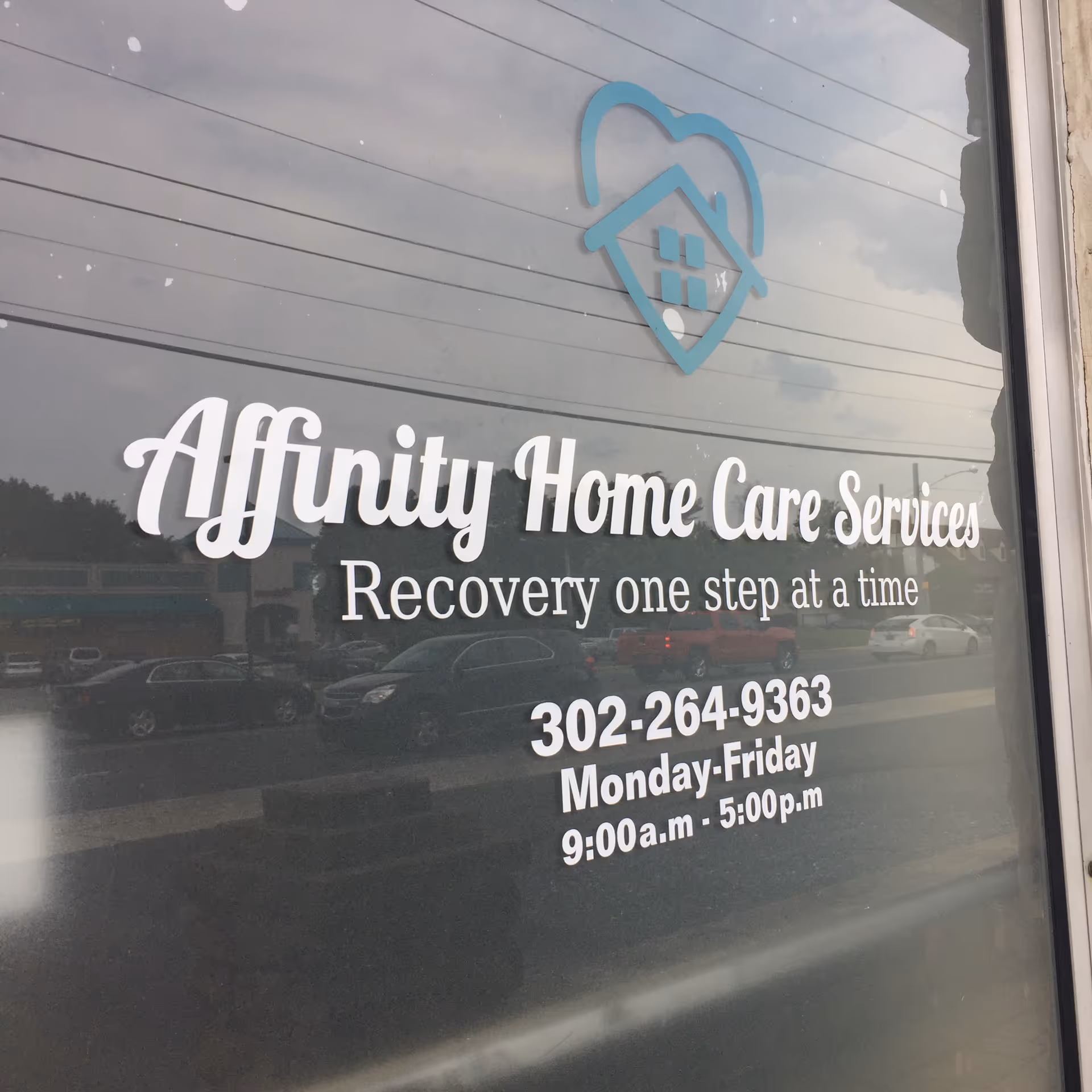 Window sign reading Affinity Home Care Services with contact details on the building front.