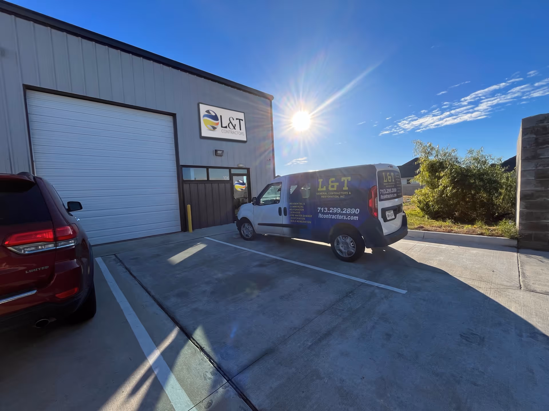 Exterior view of L&T Contractors building with a branded van parked in front.
