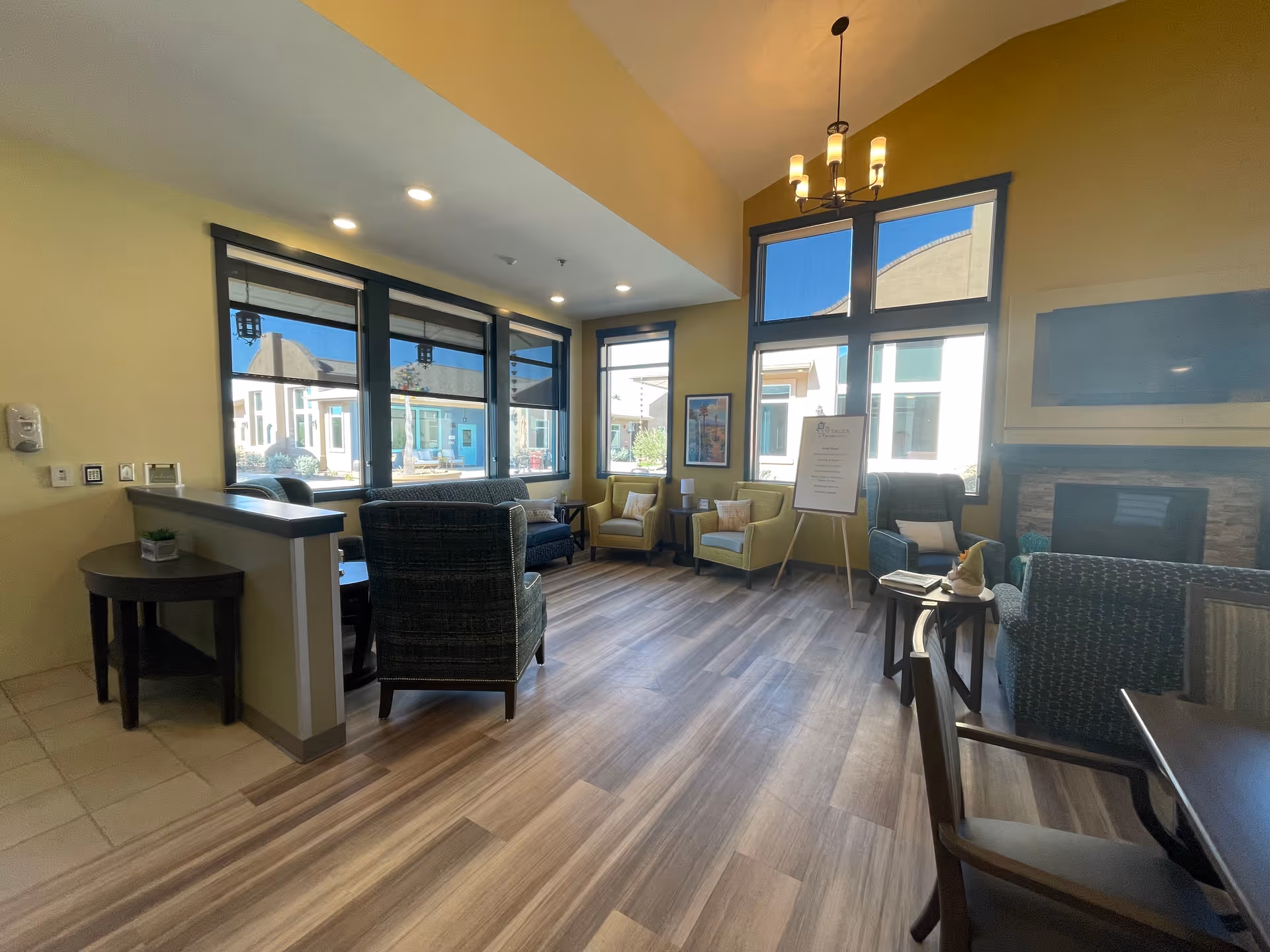 Common lounge at a senior living facility with sofas, chairs, and a fireplace.