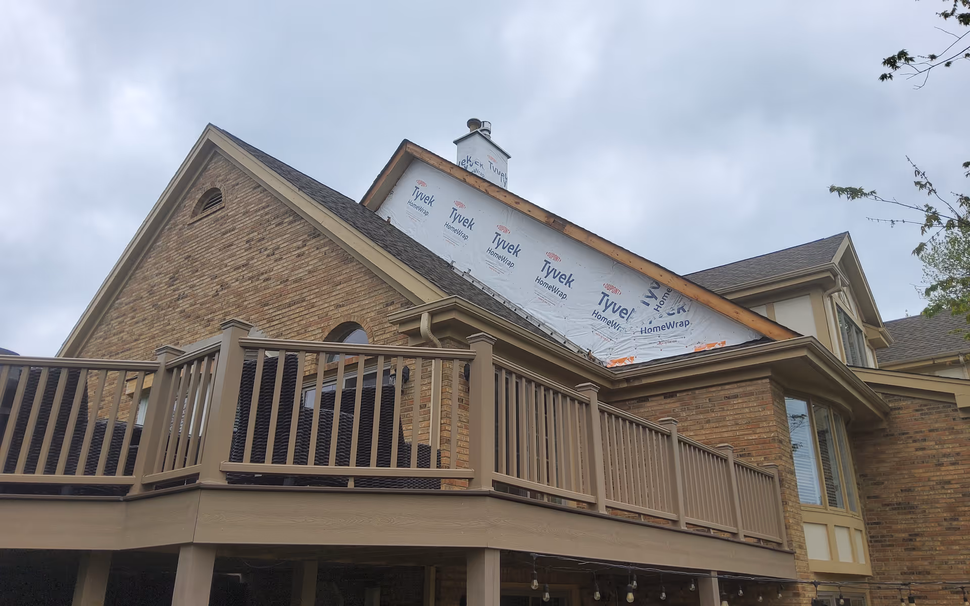 Brick senior living facility exterior with a wooden deck under construction