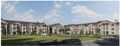 Exterior view of The Rushwood Senior Living facility showing a large, multi-story building with balconies, a landscaped lawn, and a clear blue sky with some clouds.