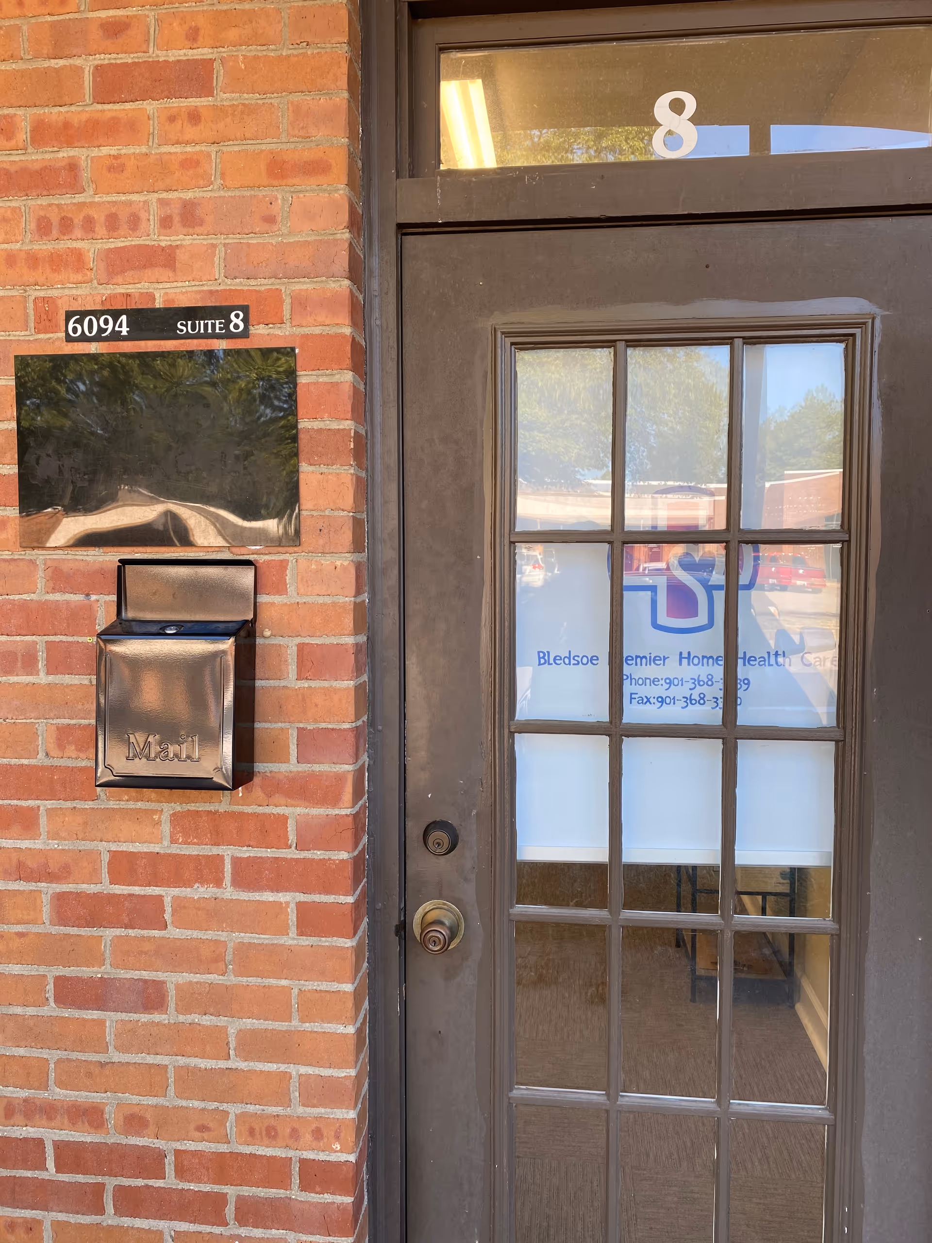 Brick building entrance with glass-paned door displaying Bledsoe Premier Home Health Care.