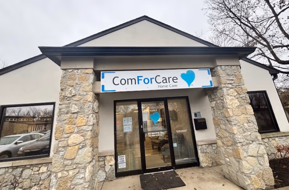 Exterior view of ComForCare Home Care office with stone pillars and blue heart logo.