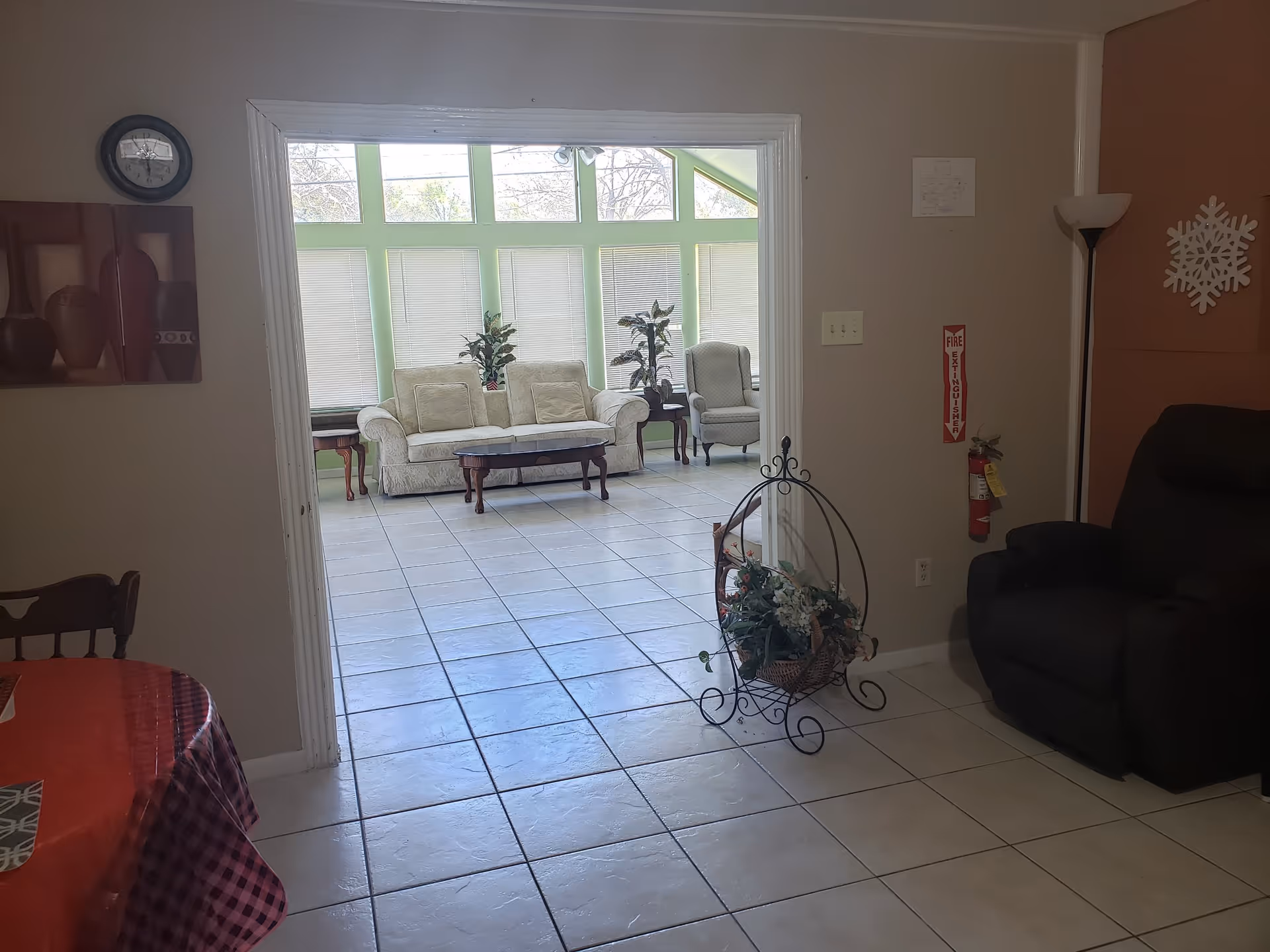 Bright living room in Praise Personal Care with sofas, plants, and sunlit windows.