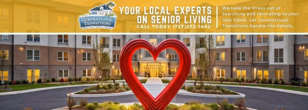 Exterior view of a multi-story senior living building with a large red heart sculpture.