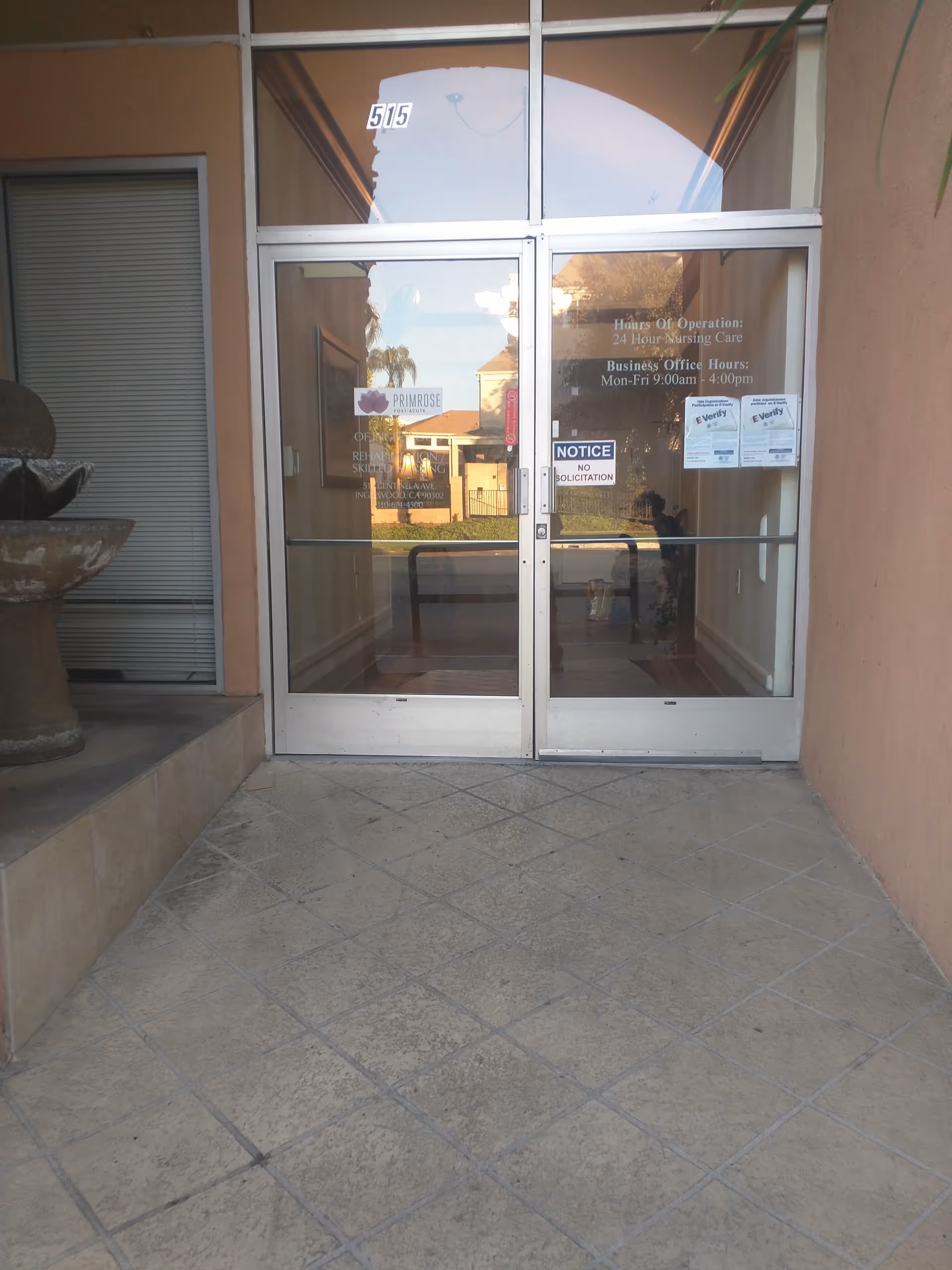 Glass double doors and tiled entrance to the Primrose Post-Acute building.